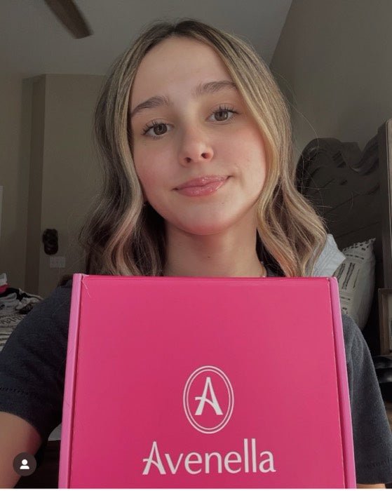 A customer resting her chin on her Avenella box