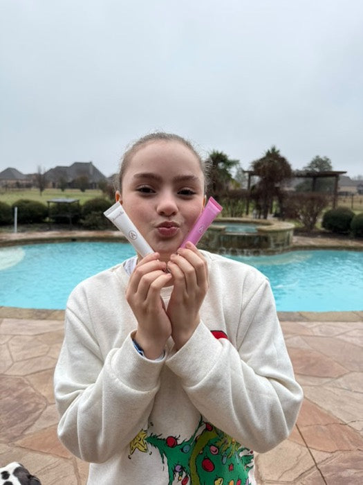 A customer blowing a kiss with her lip balms