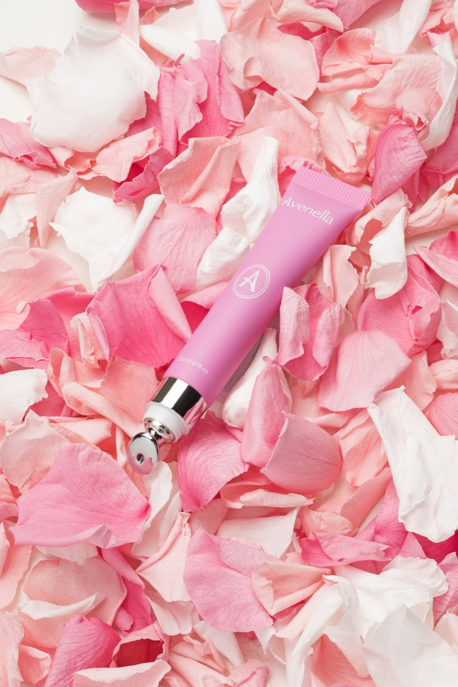Rose lip balm resting on pink rose petals