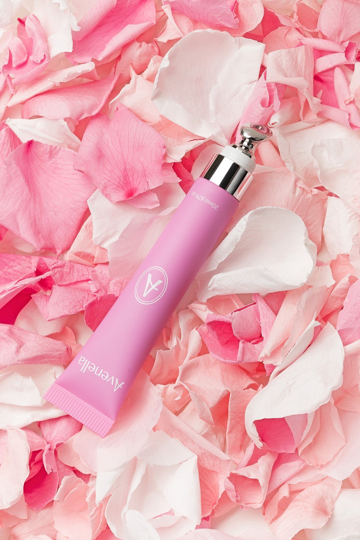 Avenella Rose lip balm resting on pink rose petals